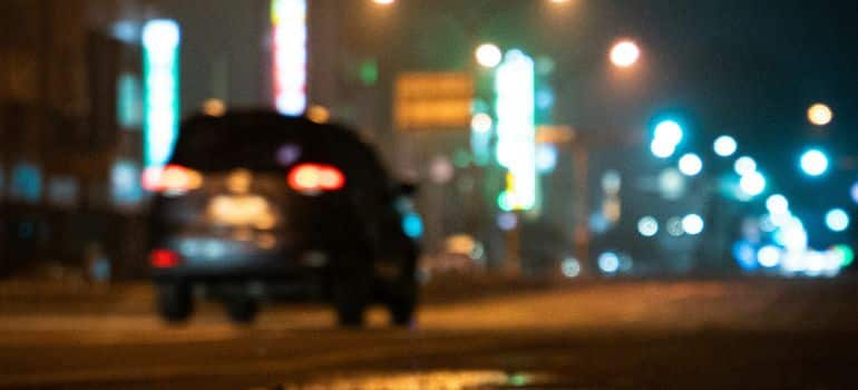 Automobil vozi po mokroj i kišovitoj cesti tijekom noći